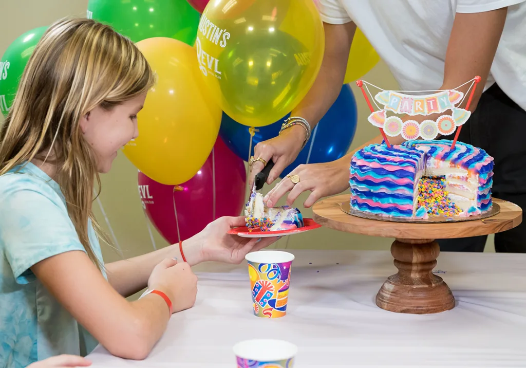 Girl grabbing a slice of cake
